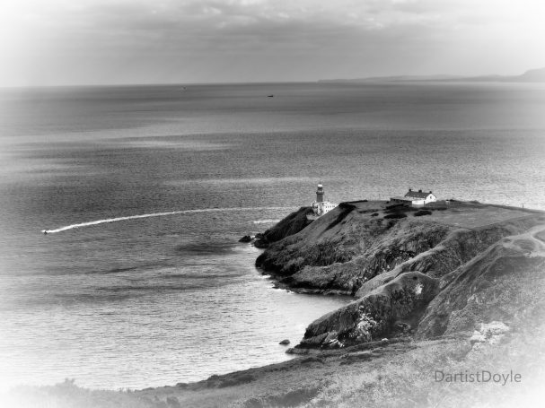 Côte escarpée surplombant l'océan, avec un phare au loin. Noir et blanc.
