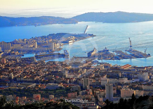 Vue panoramique de la ville côtière avec le port et la mer au loin.