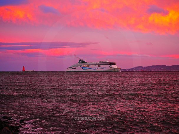 Ferry naviguant sur une mer calme sous un ciel coloré au crépuscule.